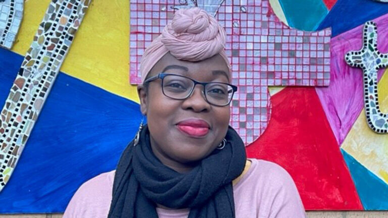 Home Office Staff member Bwalya against a colourful background