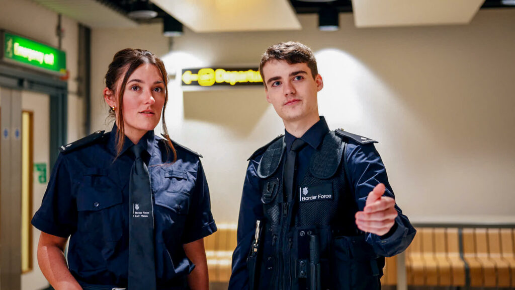 Two people standing in a corridor