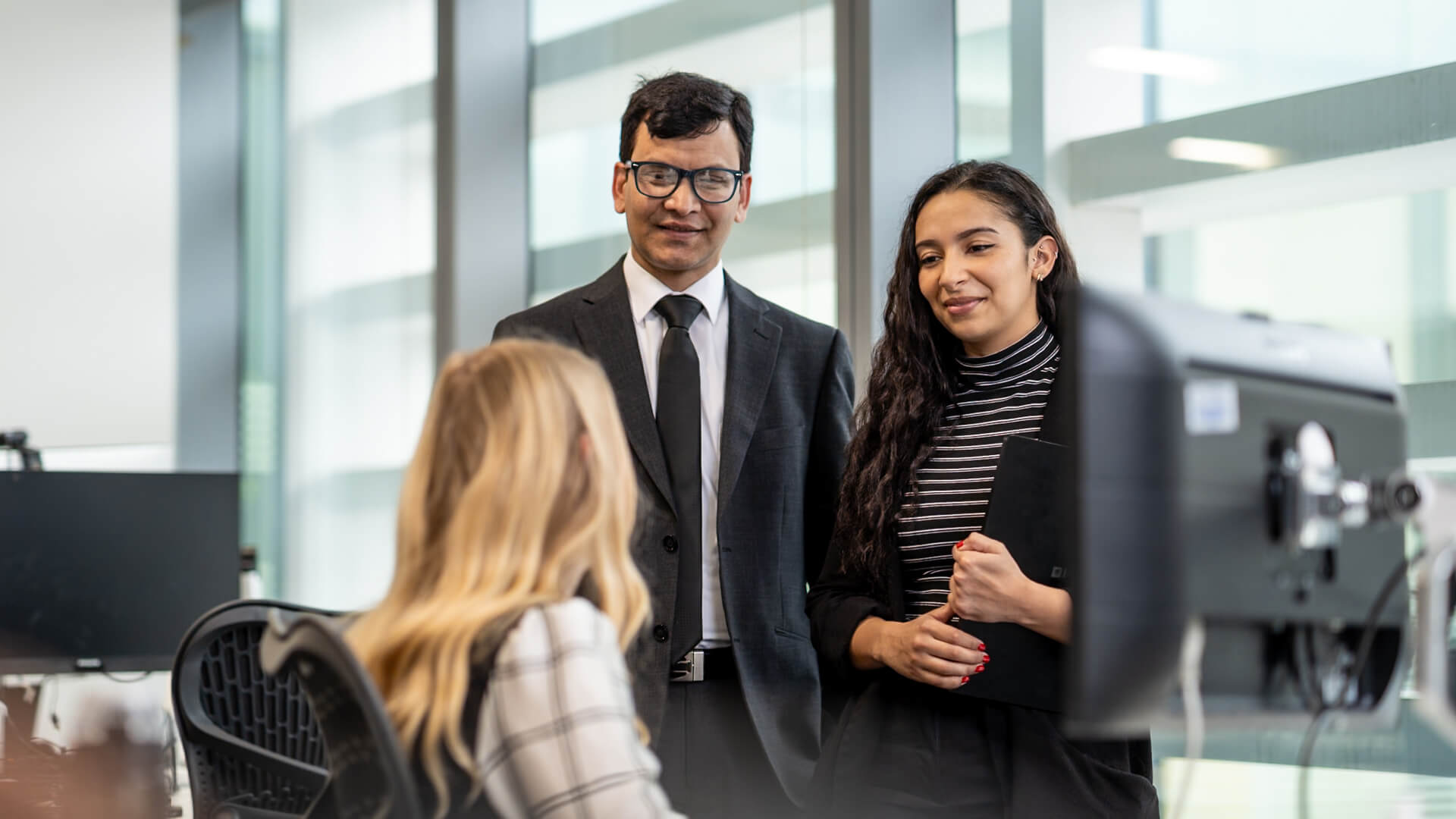 3 people talking in a modern office