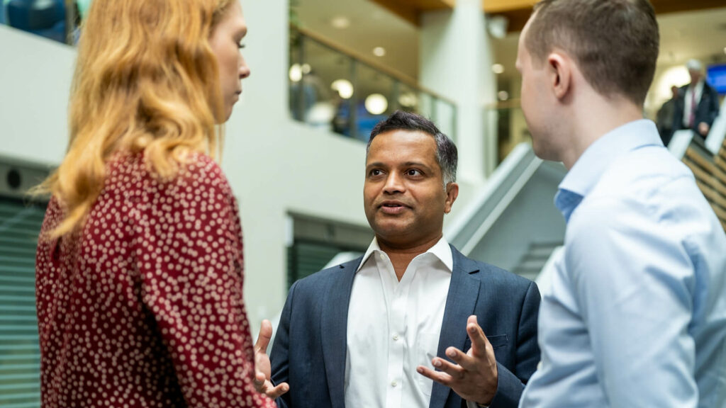 3 people talking in a modern office
